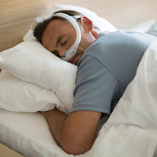Man sleeping on his stomach while on CPAP therapy. He is wearing a Philips DreamWear Gel Pillows CPAP Mask.